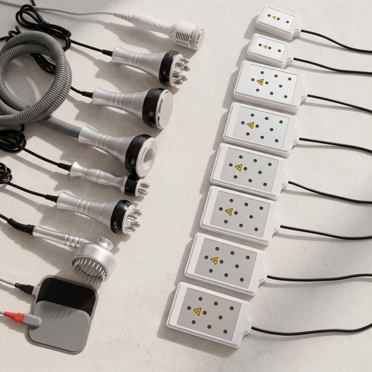 Flat lay display of all 9 attachments including 8 lipo laser pads, cold hammer, EMS electrode pads, and RF probes included in the 9-in-1 cavitation suite.